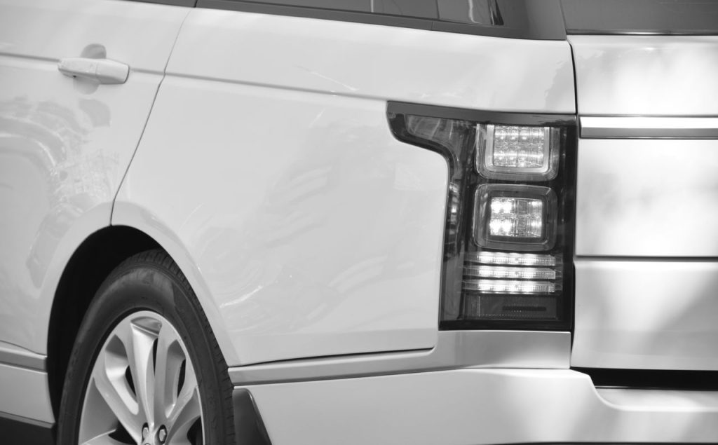Detailed black and white close-up of an SUV's taillight and rear design.